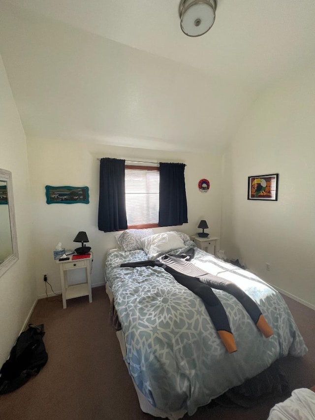 bedroom with vaulted ceiling and dark carpet