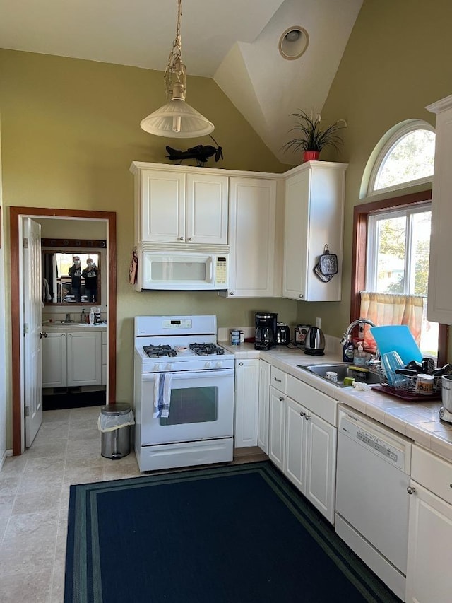 kitchen featuring white cabinets, light tile floors, and white appliances