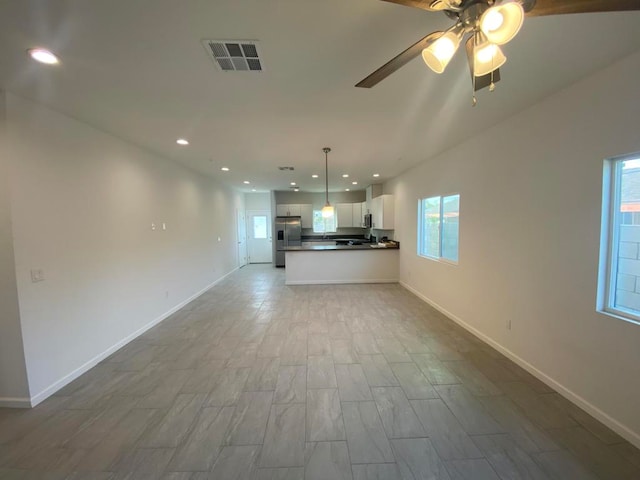 unfurnished living room featuring a healthy amount of sunlight, light hardwood / wood-style floors, and ceiling fan