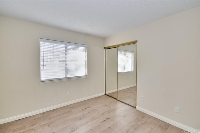 unfurnished bedroom with a closet and light hardwood / wood-style flooring