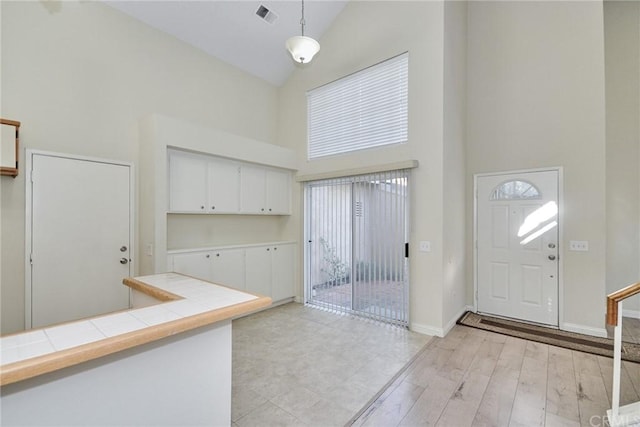 entryway with high vaulted ceiling and light tile flooring