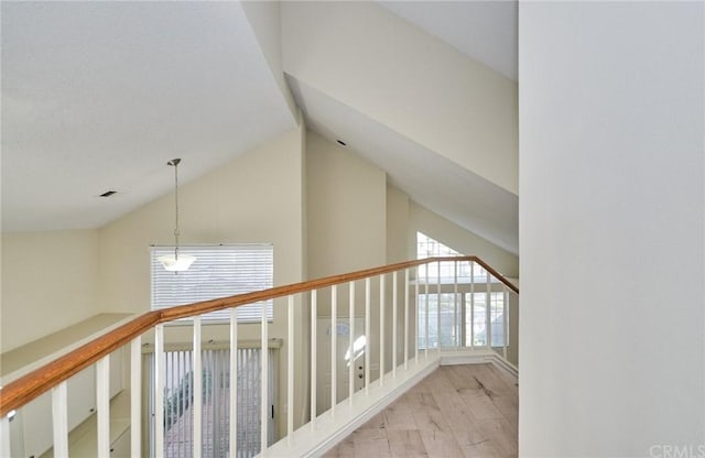 hallway featuring vaulted ceiling, a chandelier, and light hardwood / wood-style flooring