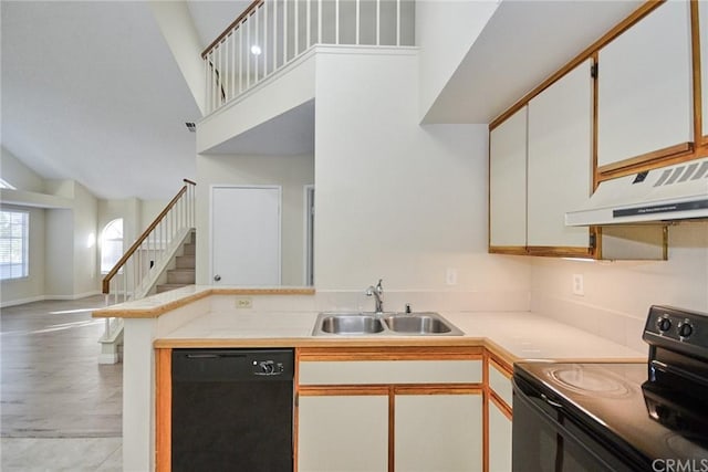 kitchen with high vaulted ceiling, custom exhaust hood, white cabinetry, black appliances, and sink