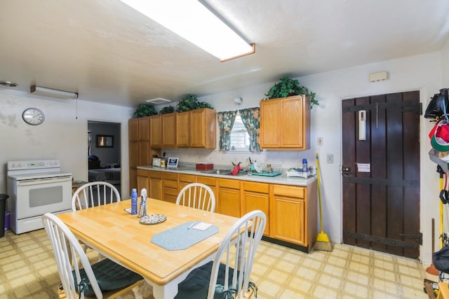 kitchen with light tile flooring, backsplash, electric range, and sink