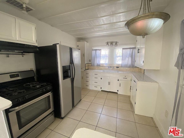 kitchen with white cabinetry, light tile flooring, appliances with stainless steel finishes, sink, and pendant lighting