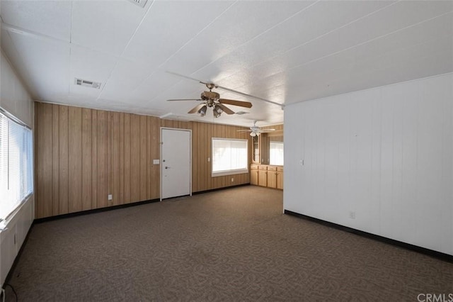 spare room with ceiling fan and dark carpet