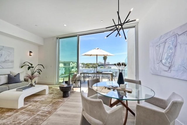 sitting room featuring an inviting chandelier, light hardwood / wood-style floors, and a wall of windows