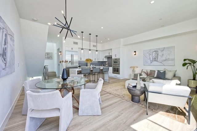 dining area with a chandelier and light hardwood / wood-style floors