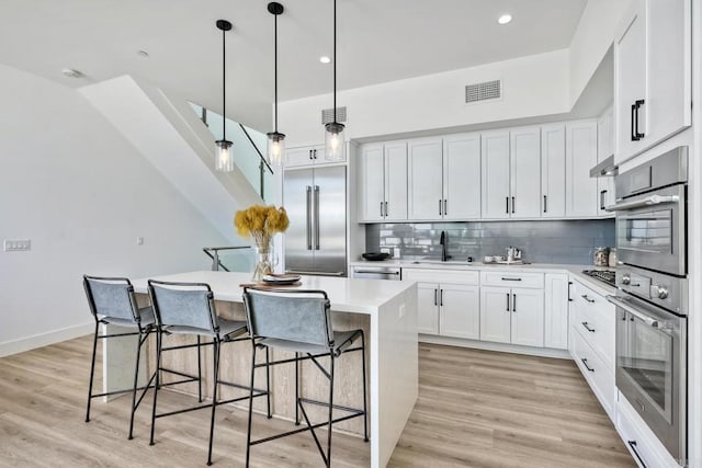 kitchen featuring white cabinetry, appliances with stainless steel finishes, and light wood-type flooring