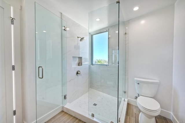 bathroom with an enclosed shower and toilet