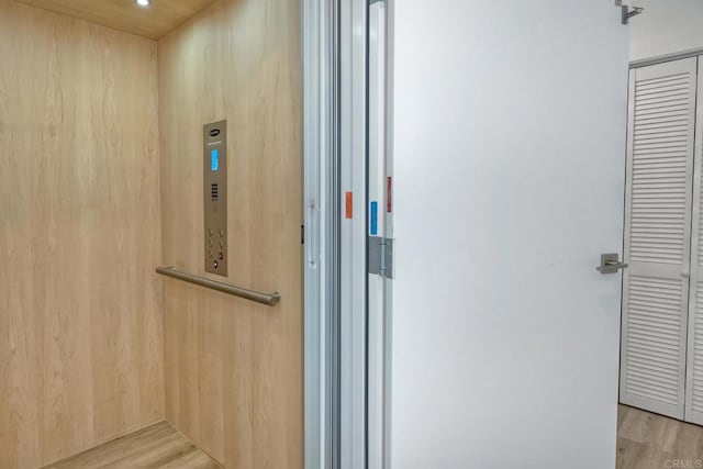 bathroom featuring elevator and hardwood / wood-style flooring