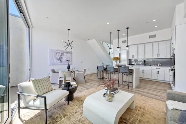 living room with light hardwood / wood-style floors and sink