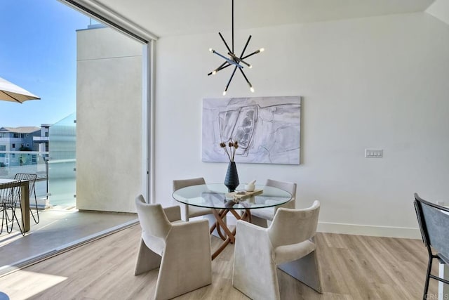 dining room with floor to ceiling windows, light hardwood / wood-style floors, and a chandelier