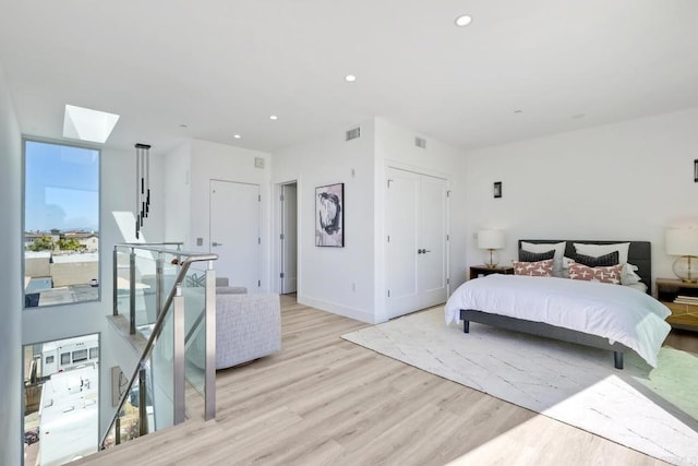 bedroom featuring a skylight and light hardwood / wood-style floors