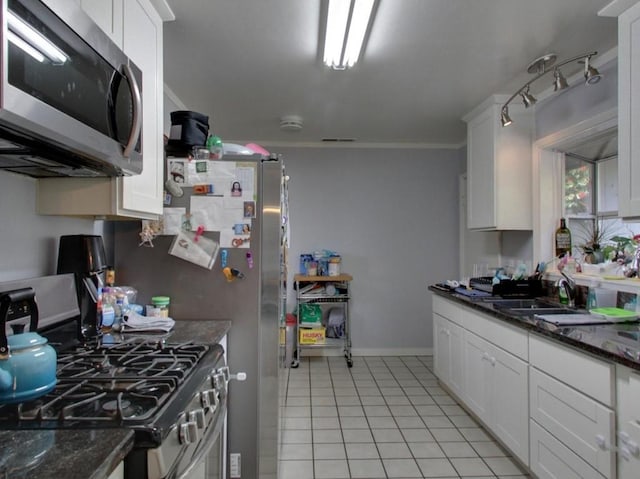 kitchen with sink, light tile floors, dark stone countertops, double oven range, and white cabinetry