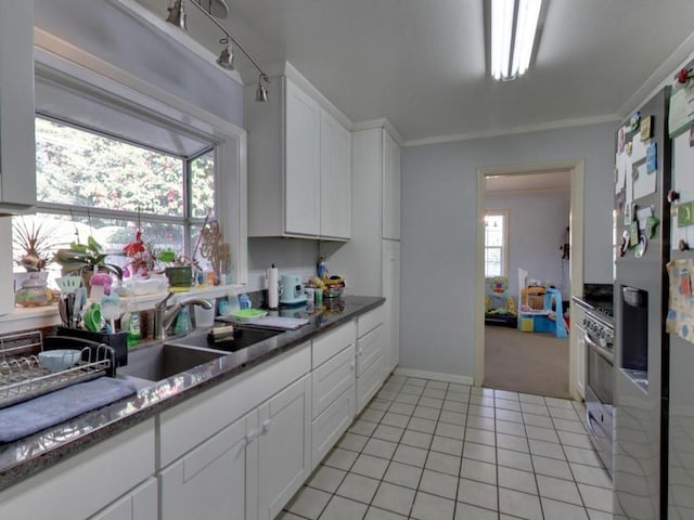 kitchen with light carpet, plenty of natural light, white cabinets, and sink