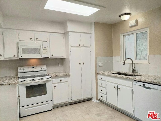 kitchen featuring white appliances, white cabinetry, and sink