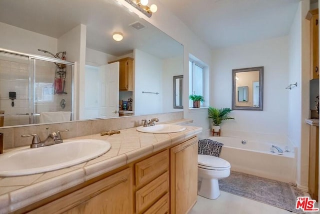 bathroom with toilet, large vanity, a bathing tub, dual sinks, and tile floors