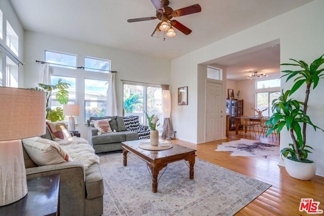 living room featuring plenty of natural light, ceiling fan, and light wood-type flooring