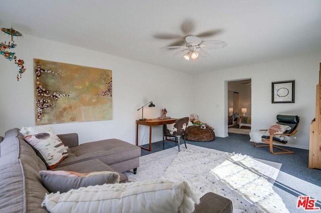 living room featuring ceiling fan and dark colored carpet