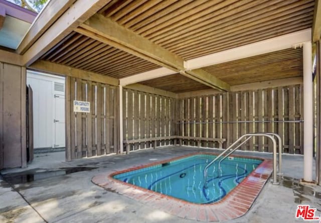 view of swimming pool featuring a hot tub