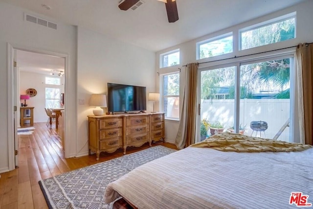 bedroom featuring access to exterior, light hardwood / wood-style floors, and ceiling fan