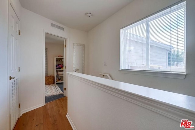 corridor featuring a wealth of natural light and hardwood / wood-style floors