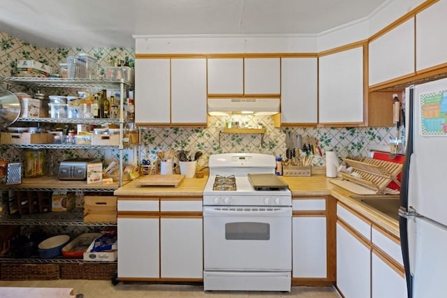 kitchen featuring range hood, tasteful backsplash, white appliances, and white cabinets