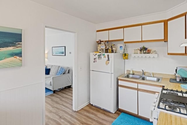 kitchen featuring white cabinetry, sink, white fridge, and light wood-type flooring