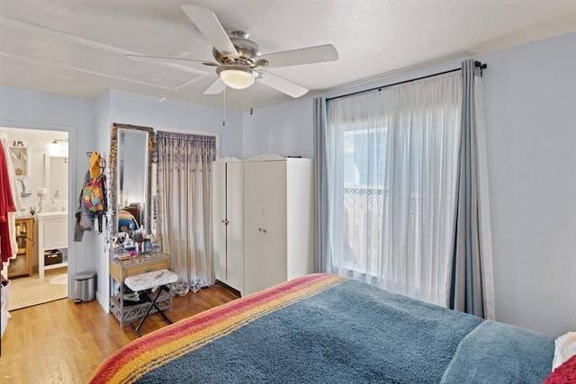 bedroom featuring light hardwood / wood-style floors, ceiling fan, and ensuite bathroom