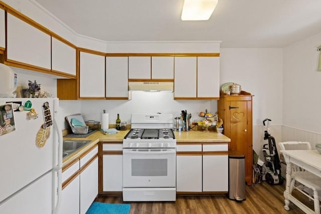 kitchen featuring white appliances, white cabinetry, wood-type flooring, and sink