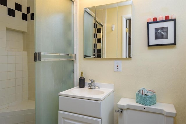 bathroom with tiled shower, toilet, and vanity