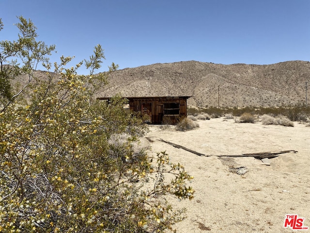 rear view of house featuring a mountain view and an outdoor structure