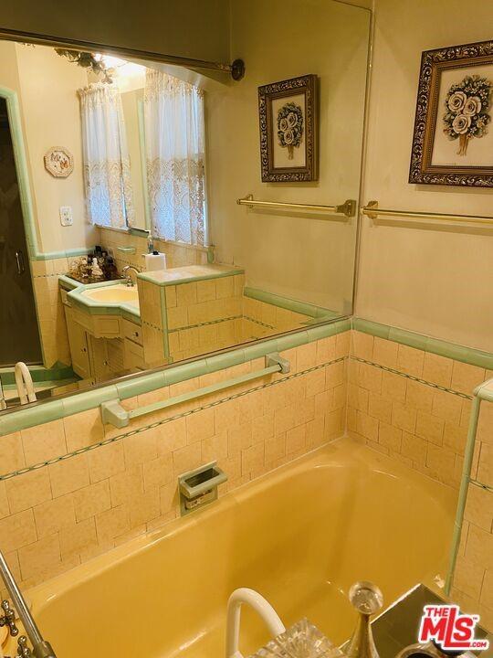 bathroom with a tub and vanity