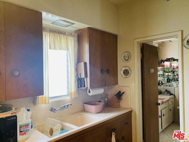 kitchen featuring tasteful backsplash and light tile flooring