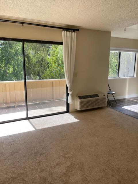 unfurnished living room featuring a textured ceiling and carpet flooring