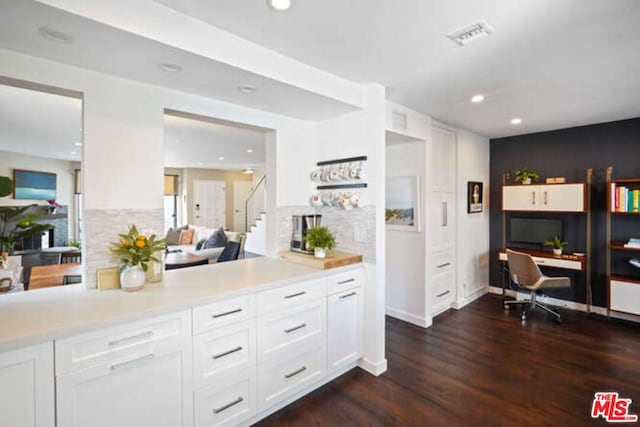 kitchen with kitchen peninsula, white cabinetry, and dark hardwood / wood-style flooring