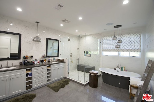 bathroom featuring plus walk in shower, tile walls, and vanity