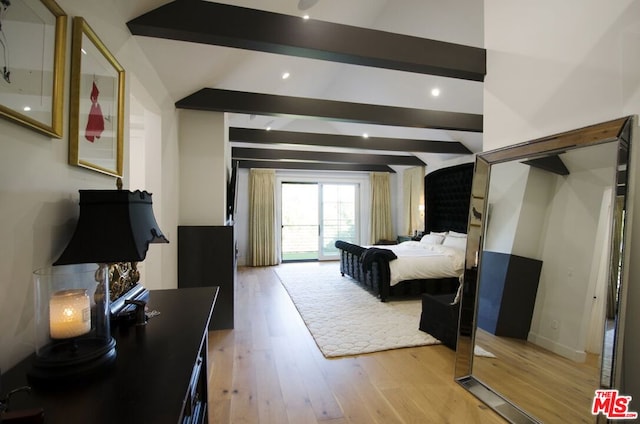 bedroom with vaulted ceiling with beams and light hardwood / wood-style floors