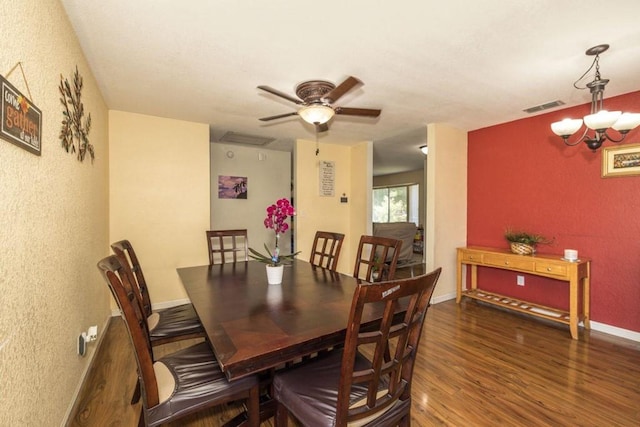 dining room featuring dark wood-type flooring and ceiling fan with notable chandelier