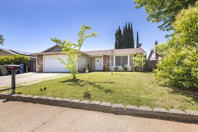 ranch-style home featuring solar panels, a front yard, and a garage