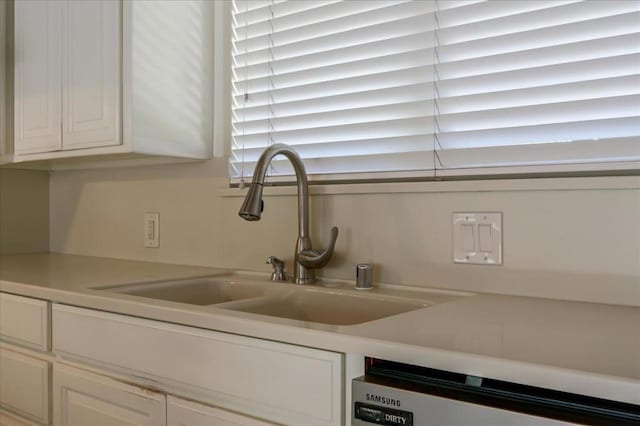 interior details featuring dishwasher, sink, and white cabinets