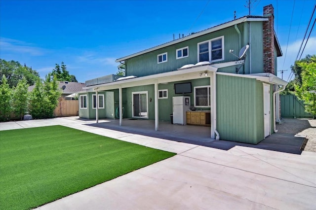 back of property featuring a patio and a lawn