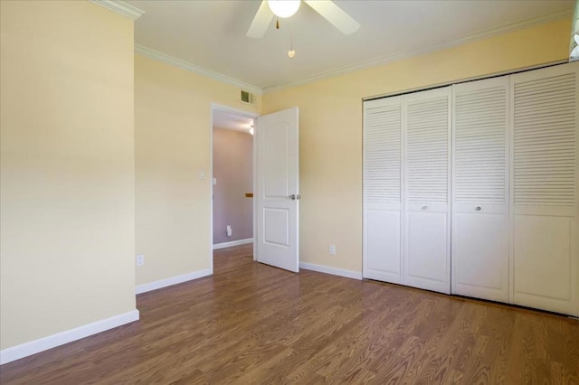 unfurnished bedroom with wood-type flooring, ornamental molding, ceiling fan, and a closet