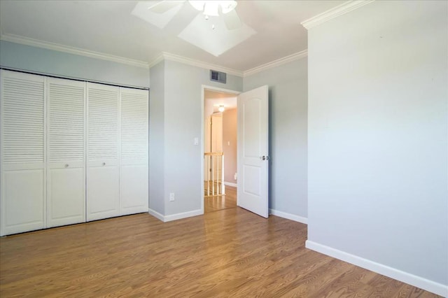 unfurnished bedroom with ceiling fan, a closet, light hardwood / wood-style flooring, and ornamental molding