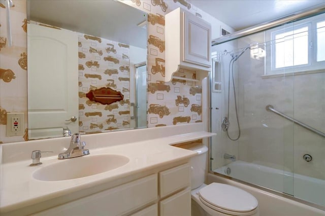 full bathroom with vanity, toilet, and combined bath / shower with glass door