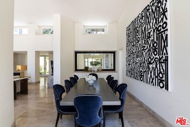 dining room featuring a high ceiling and light hardwood / wood-style floors