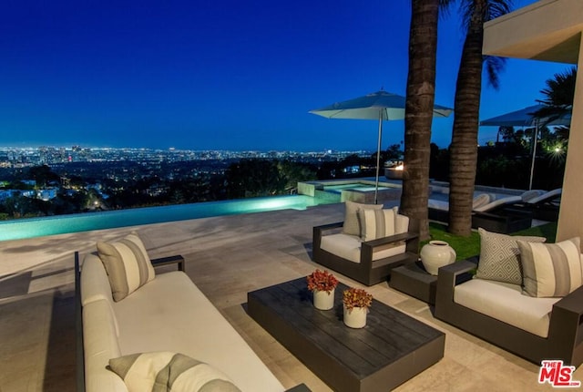 patio terrace at twilight with an outdoor hangout area and a pool with hot tub