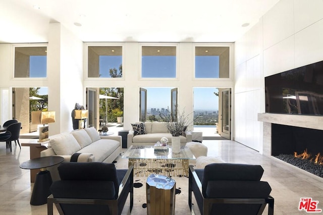 living room featuring a high end fireplace and a high ceiling