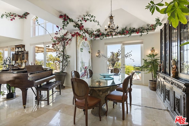 dining room featuring high vaulted ceiling and a chandelier